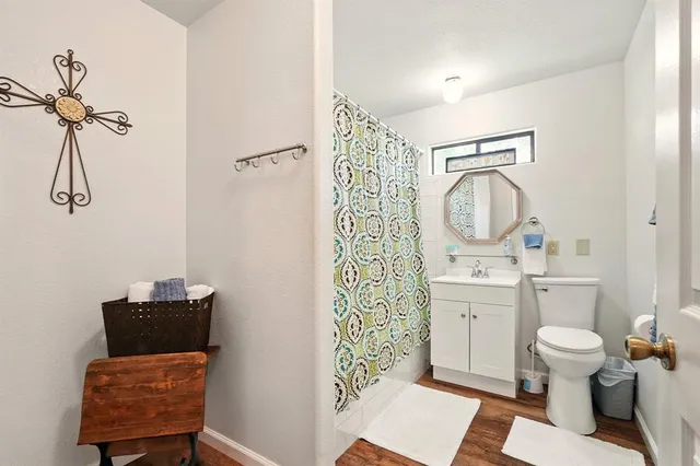 a bathroom with a toilet sink vanity tub and mirror