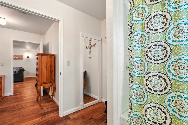 a view of a hallway with elevator and wooden floor