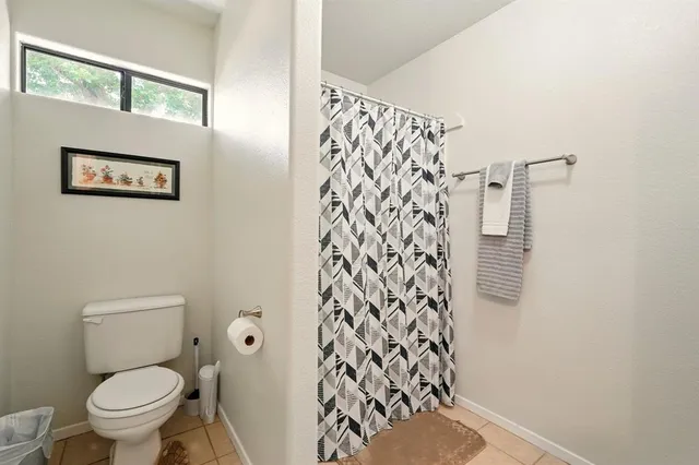 a white toilet sitting next to a shower curtain