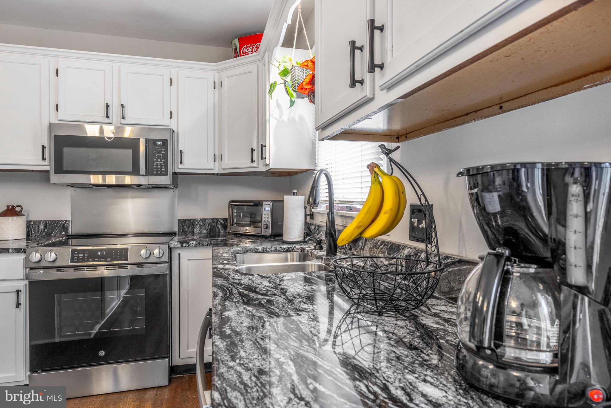 303 Gray Mt Circle Elkton, MD 21921 - Photo 15 of 35 a kitchen with stainless steel appliances granite countertop a stove a sink and a microwave