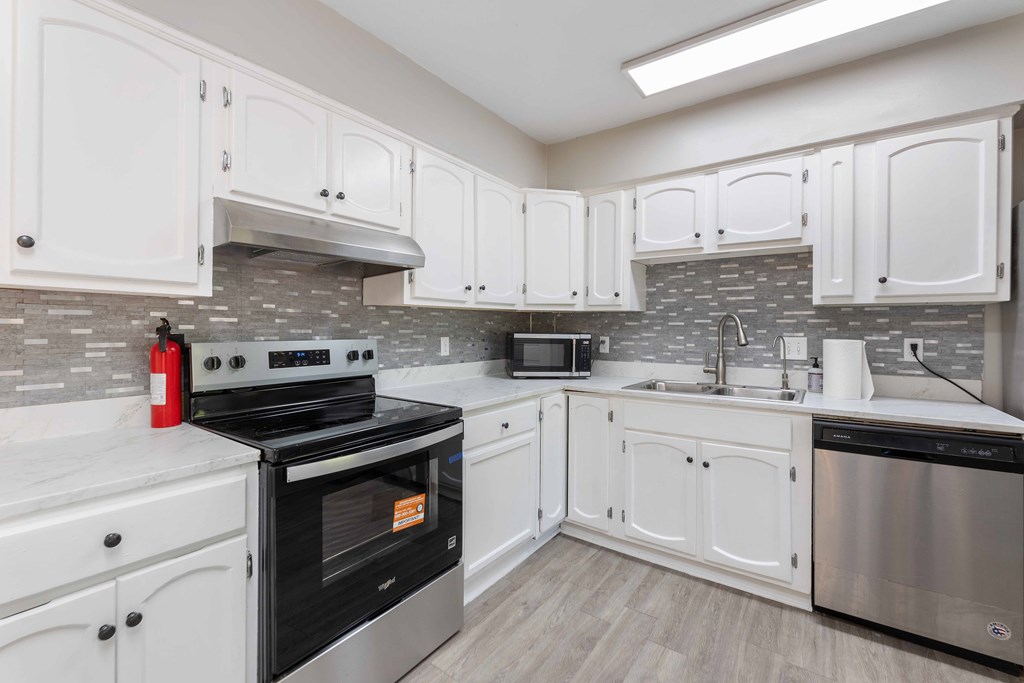 4601 Ritch Haven Road Columbus, GA 31909 - Photo 6 of 24 a kitchen with granite countertop white cabinets and stainless steel appliances