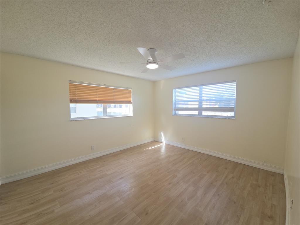7901 South Colony Circle, Unit 101 Tamarac, FL 33321 - Photo 15 of 28 a view of an empty room with wooden floor and a window