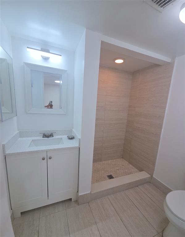 7901 South Colony Circle, Unit 101 Tamarac, FL 33321 - Photo 22 of 28 a bathroom with a shower a sink a toilet and mirror