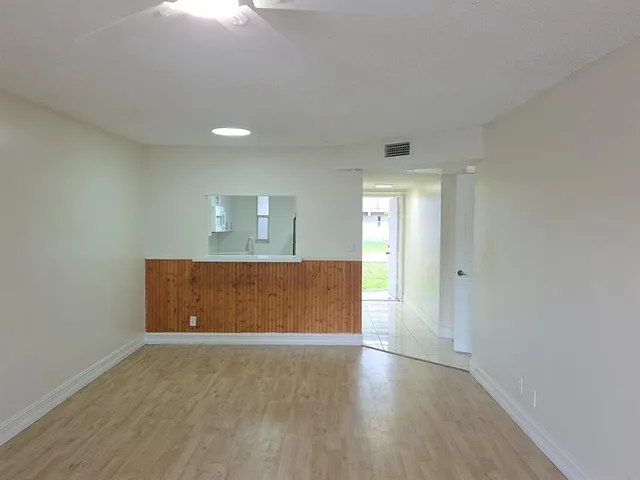 a view of an empty room with wooden floor