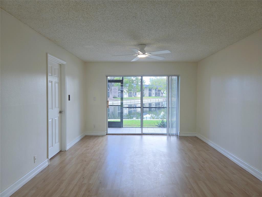 7901 South Colony Circle, Unit 101 Tamarac, FL 33321 - Photo 9 of 28 wooden floor in an empty room with a window