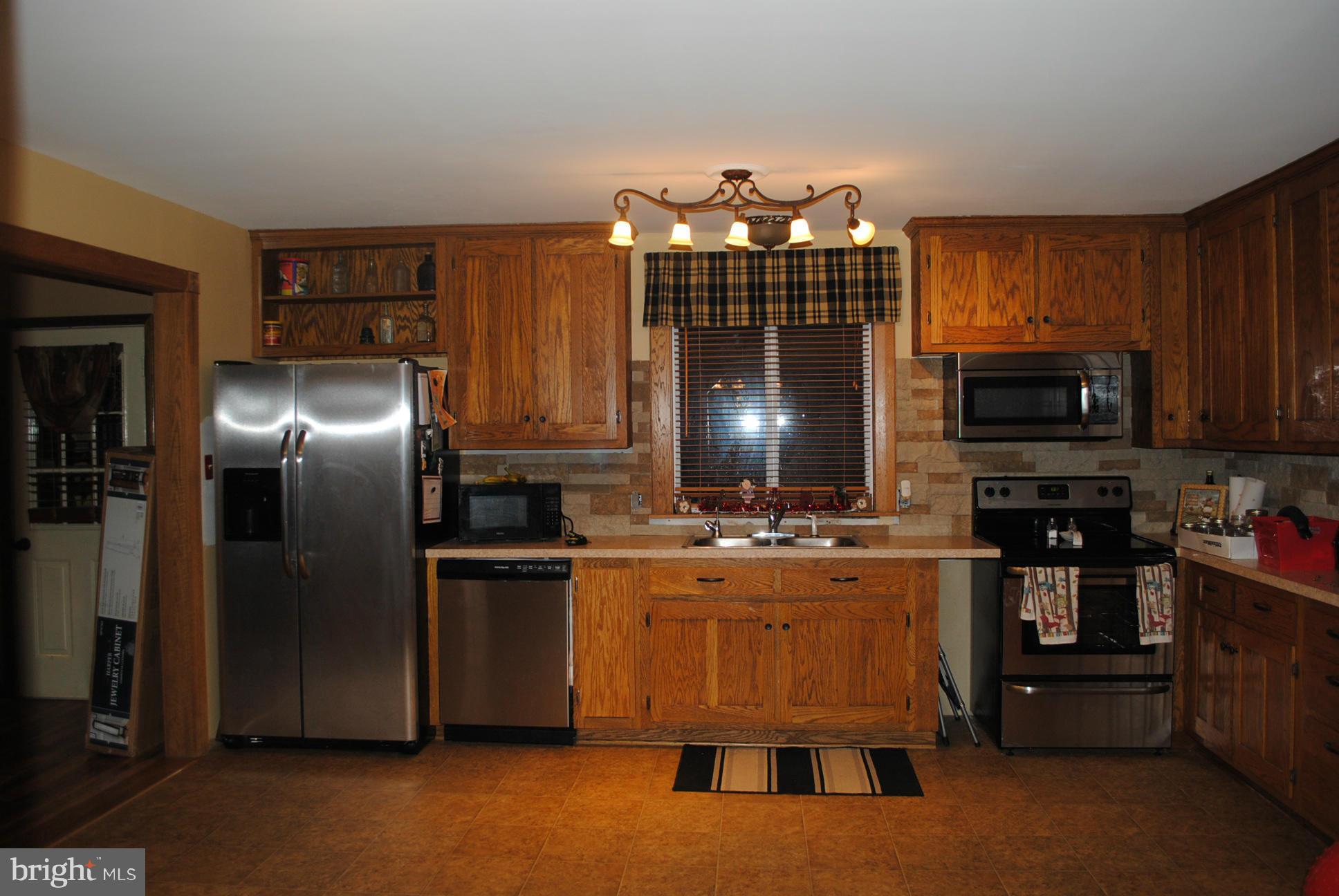 26 Messick Road Strasburg, VA 22657 - Photo 4 of 28 a kitchen with microwave a refrigerator and chairs