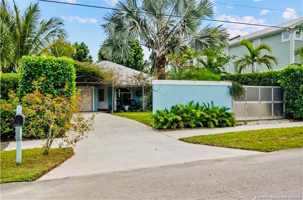 a front view of a house with a yard and potted plants