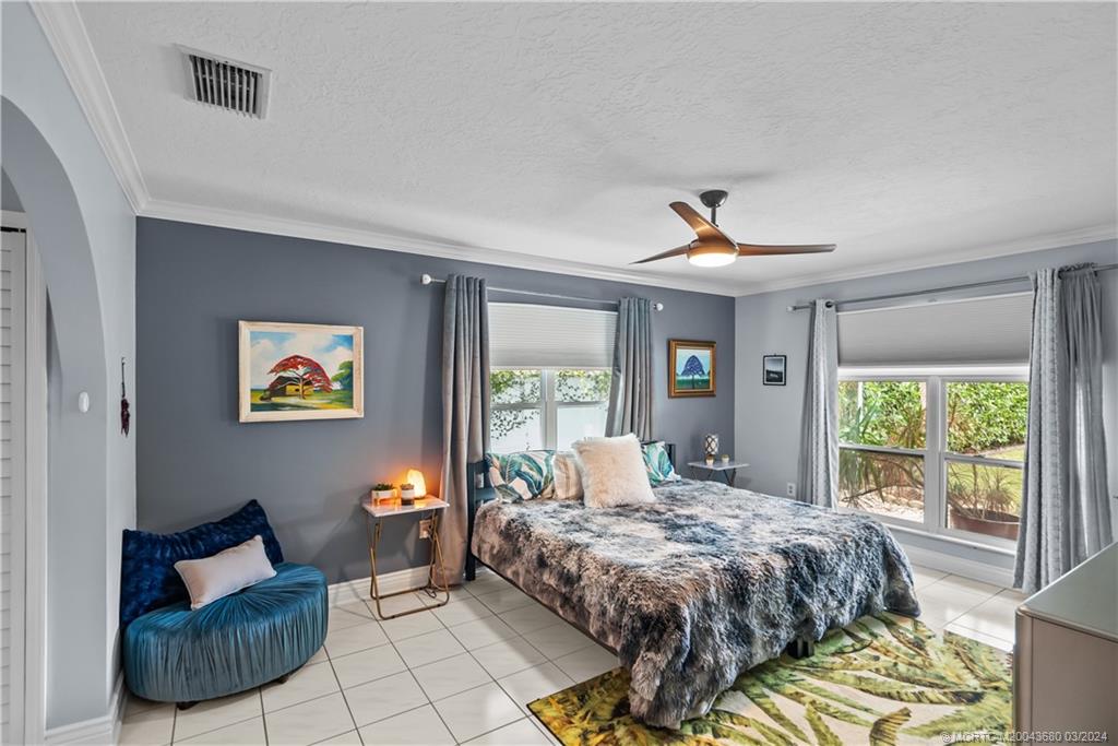 9182 Southeast Apollo Street Hobe Sound, FL 33455 - Photo 12 of 26 a bedroom with a bed and a couch