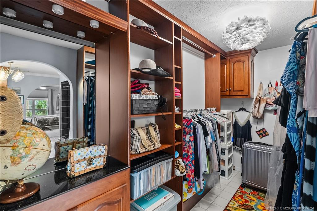 9182 Southeast Apollo Street Hobe Sound, FL 33455 - Photo 15 of 26 a view of walk in closet with clothes and shoes