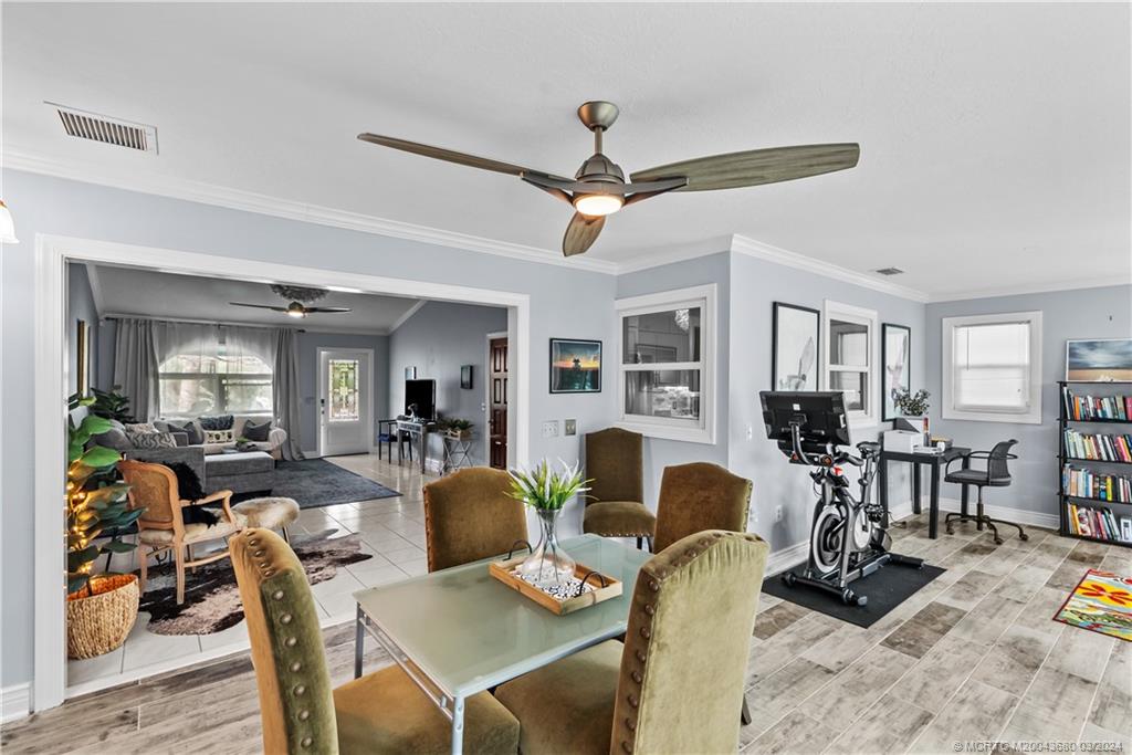 9182 Southeast Apollo Street Hobe Sound, FL 33455 - Photo 16 of 26 a view of a dining room with furniture and wooden floor