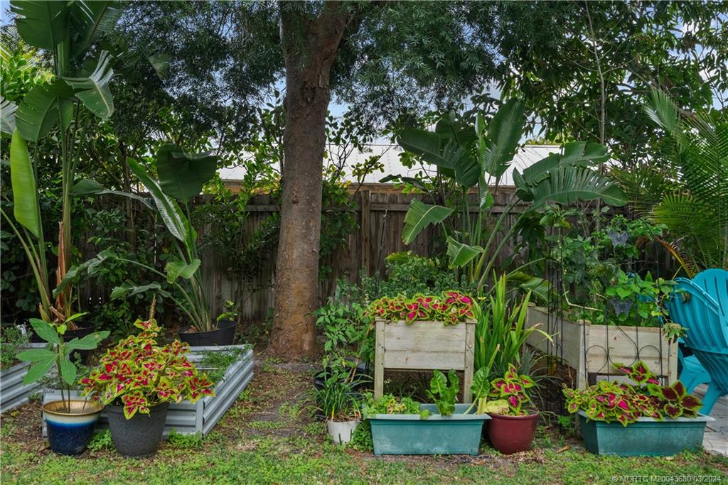 9182 Southeast Apollo Street Hobe Sound, FL 33455 - Photo 20 of 26 a view of a garden with a fountain