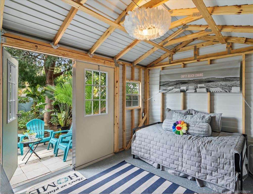 9182 Southeast Apollo Street Hobe Sound, FL 33455 - Photo 22 of 26 a bedroom with furniture and a potted plant