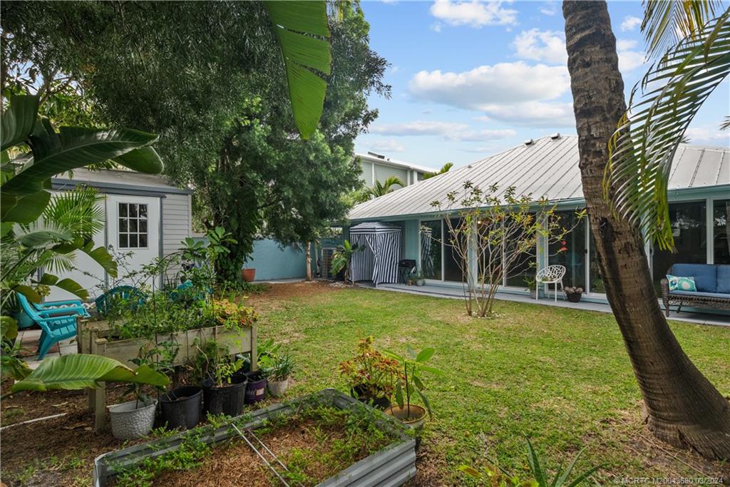 9182 Southeast Apollo Street Hobe Sound, FL 33455 - Photo 24 of 26 front view of a house with a yard