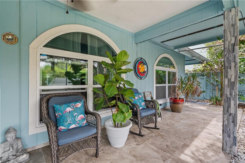 9182 Southeast Apollo Street Hobe Sound, FL 33455 - Photo 4 of 26 a front view of a house with garden and sitting area
