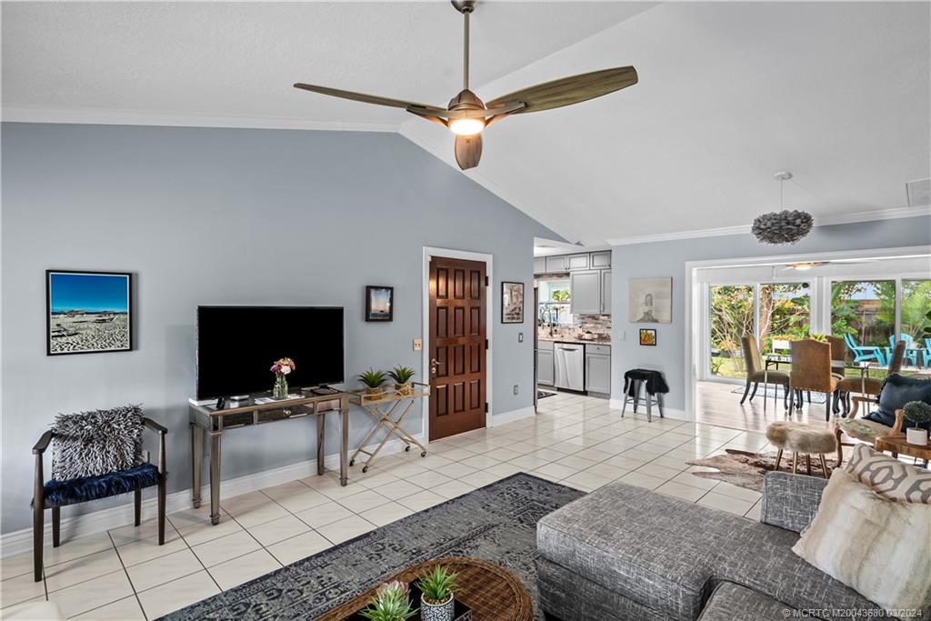 9182 Southeast Apollo Street Hobe Sound, FL 33455 - Photo 6 of 26 a living room with furniture a fireplace and a flat screen tv
