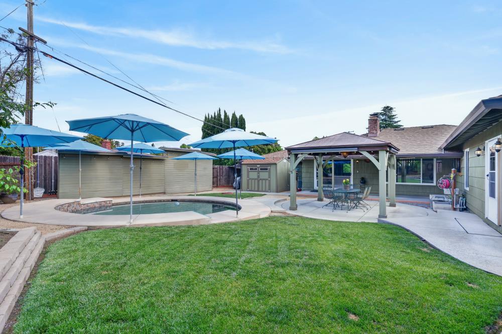 4831 Jan Drive Carmichael, CA 95608 - Photo 45 of 69 a patio with a table and chairs under an umbrella