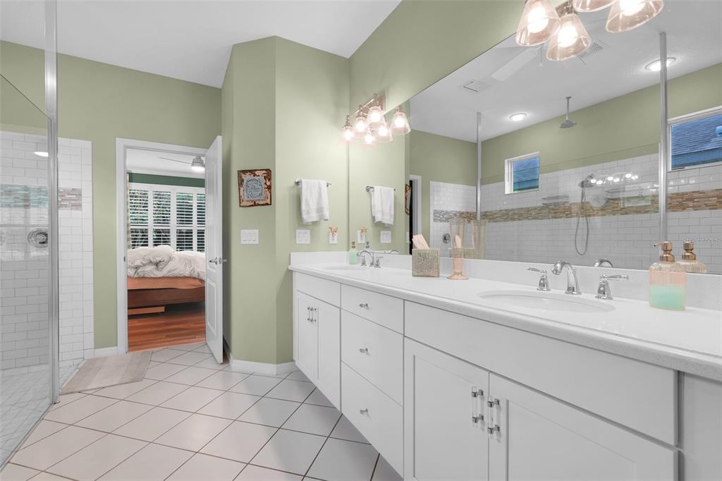 1038 Timbervale Trail Clermont, FL 34715 - Photo 27 of 54 a spacious en suite bathroom with double sink and a mirror
