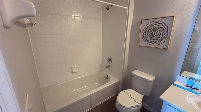 a kitchen with stainless steel appliances granite countertop a stove top oven a sink a dining table and chairs with wooden floor