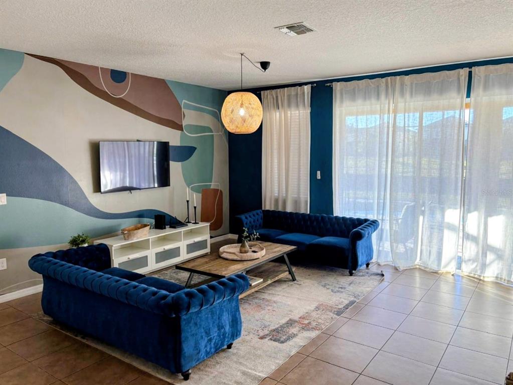 4445 Shiva Loop Kissimmee, FL 34746 - Photo 28 of 33 a living room with furniture and a large window