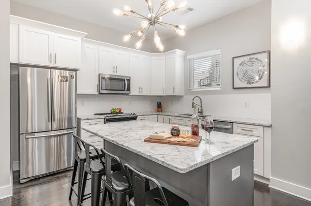 a kitchen with stainless steel appliances granite countertop a sink stove and refrigerator
