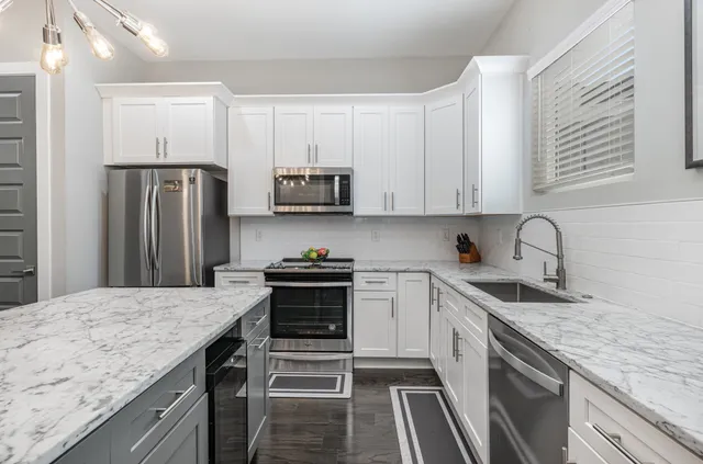 a kitchen with stainless steel appliances granite countertop a sink stove and refrigerator