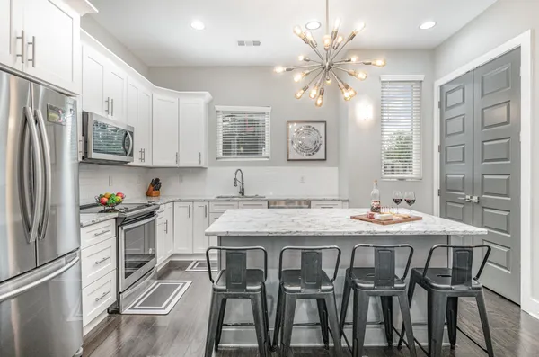 a kitchen with stainless steel appliances granite countertop a sink and a refrigerator