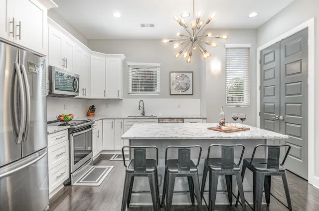 a kitchen with stainless steel appliances granite countertop a sink and a refrigerator
