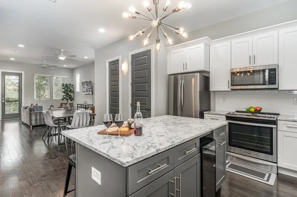 a kitchen with stainless steel appliances granite countertop a stove refrigerator and cabinets