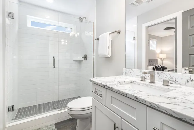 a bathroom with a granite countertop sink toilet and shower