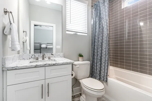 a bathroom with a granite countertop toilet a sink and a bathtub