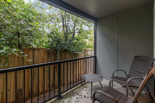 a balcony with wooden floor and outdoor seating