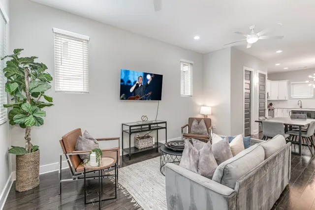 a living room with furniture a flat screen tv and a large window