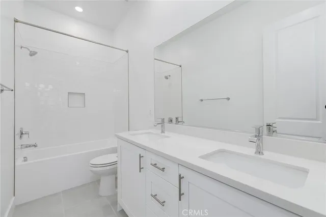 a bathroom with a sink toilet double vanity and shower
