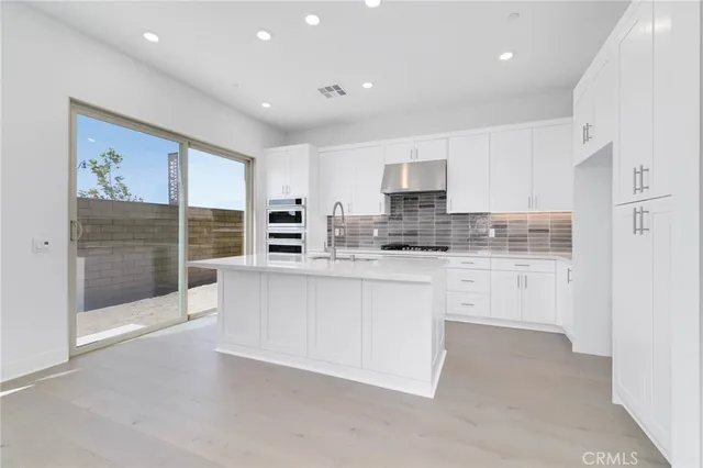 a kitchen with stainless steel appliances granite countertop a stove a sink and a refrigerator