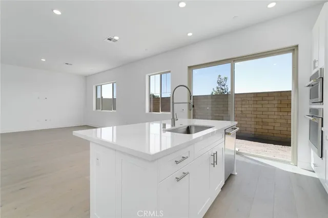 a kitchen with sink and mirror