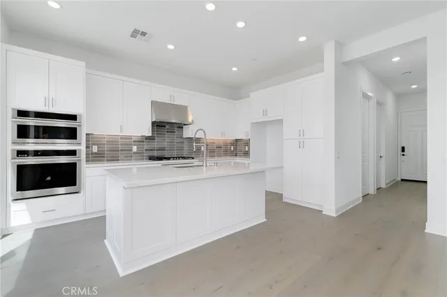 a kitchen with stainless steel appliances granite countertop a stove and a refrigerator