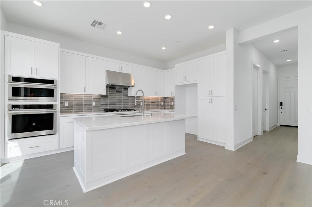 208 Lily Loop Irvine, CA 92618 - Photo 6 of 23 a kitchen with stainless steel appliances granite countertop a stove and a refrigerator