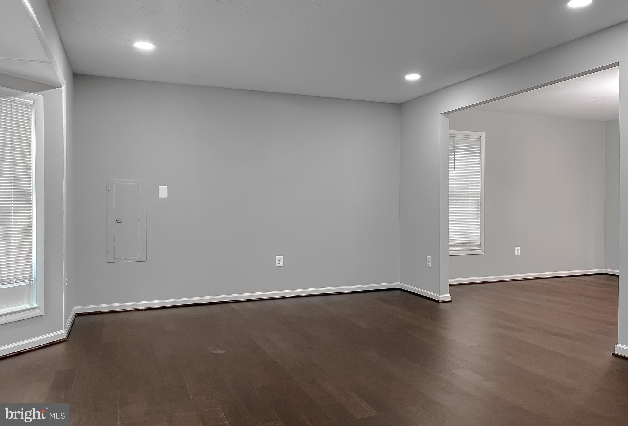 29810 Washington Road Mechanicsville, MD 20659 - Photo 14 of 44 an empty room with wooden floor and windows with curtains
