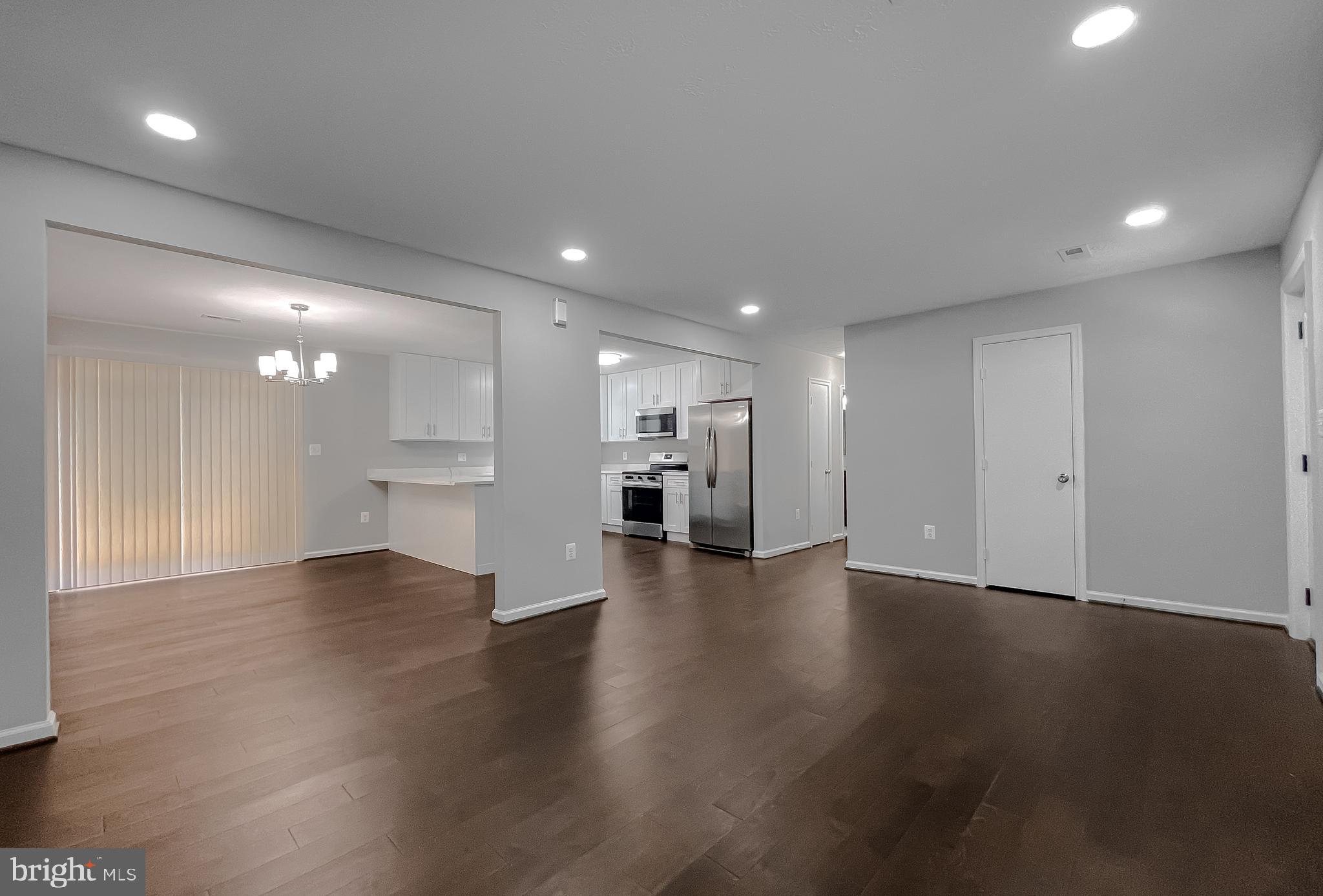 29810 Washington Road Mechanicsville, MD 20659 - Photo 15 of 44 a view of an empty room with wooden floor kitchen view and a window