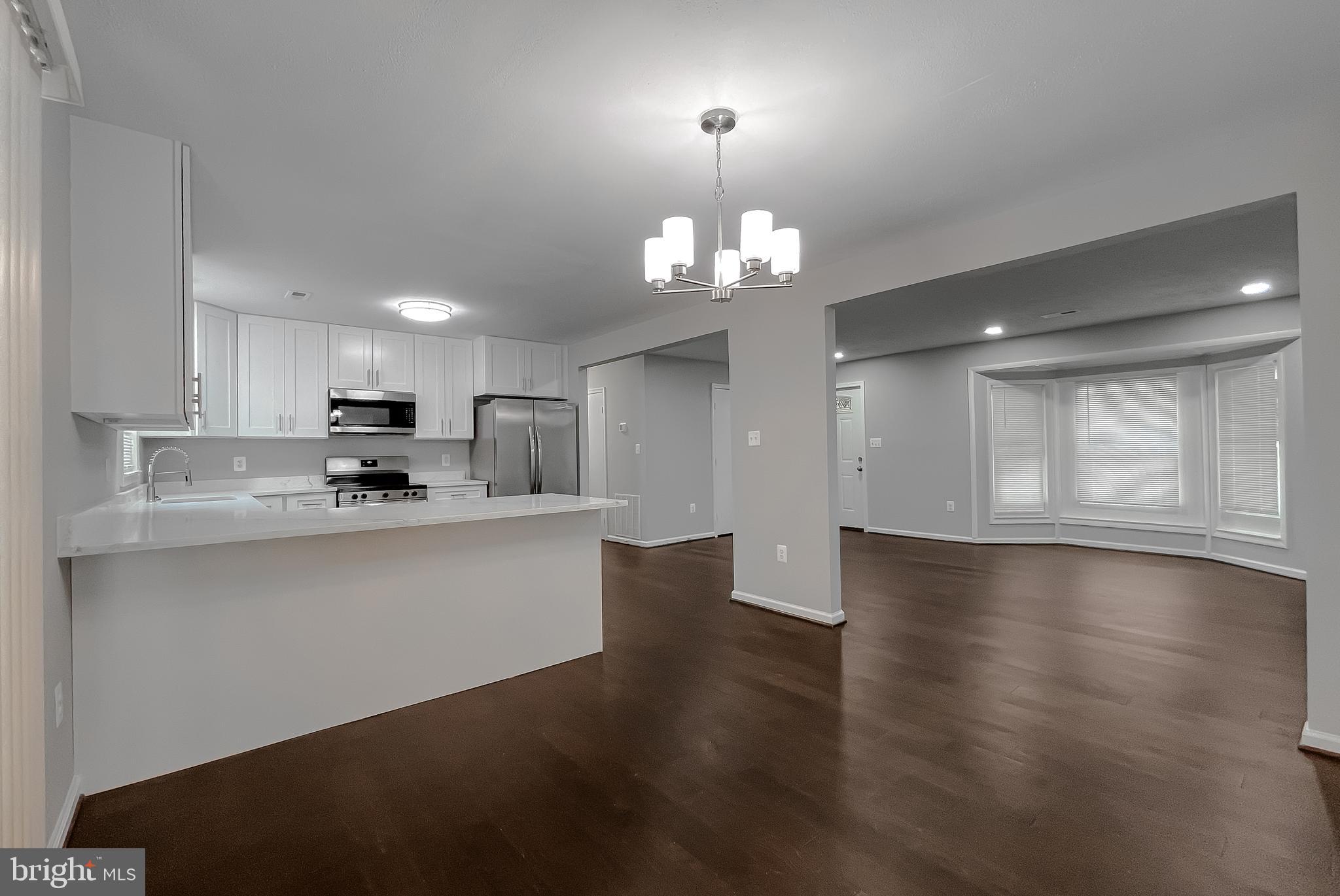 29810 Washington Road Mechanicsville, MD 20659 - Photo 23 of 44 a view of a kitchen with a sink wooden cabinets and a chandelier