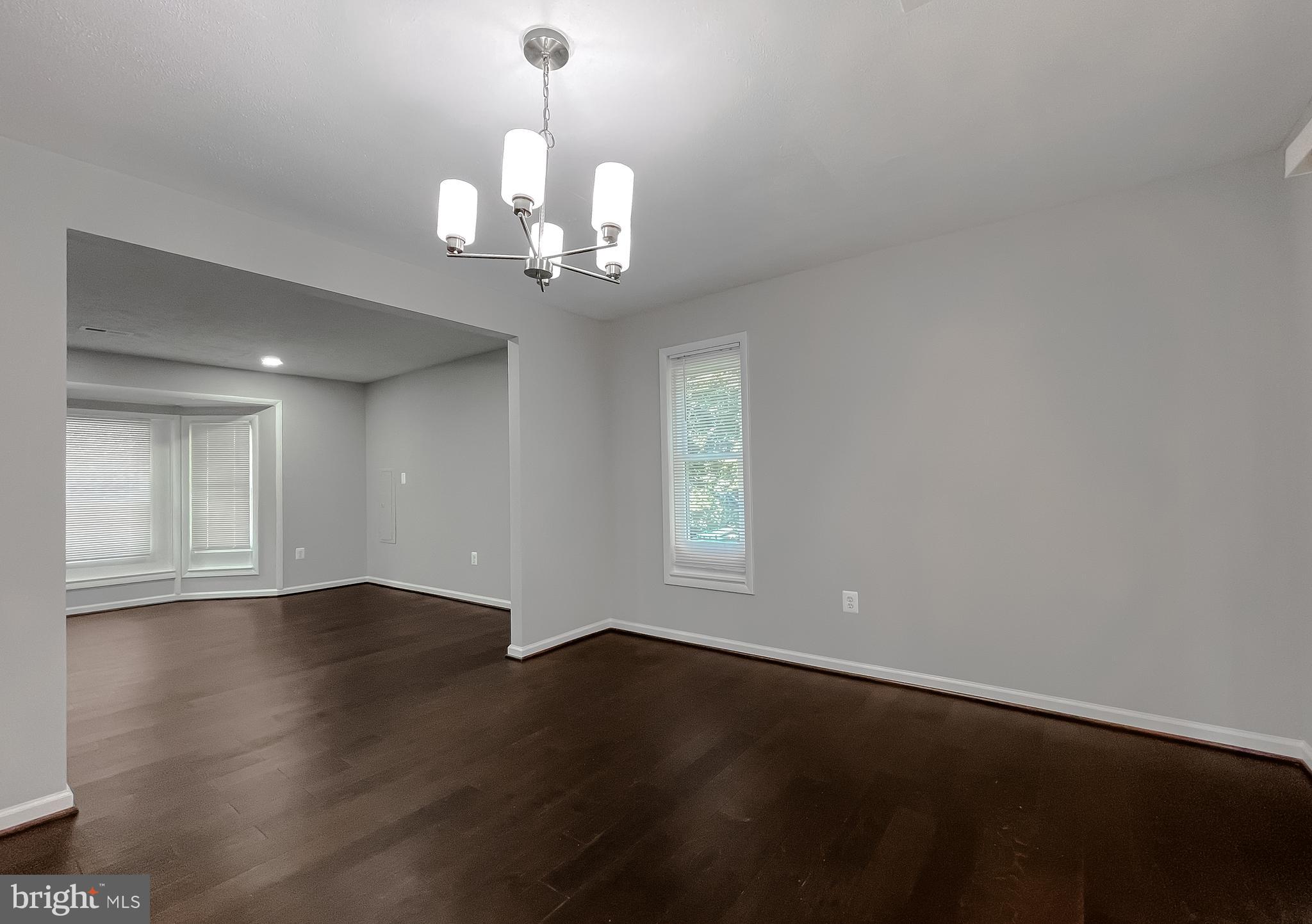 29810 Washington Road Mechanicsville, MD 20659 - Photo 25 of 44 an empty room with wooden floor chandelier and windows