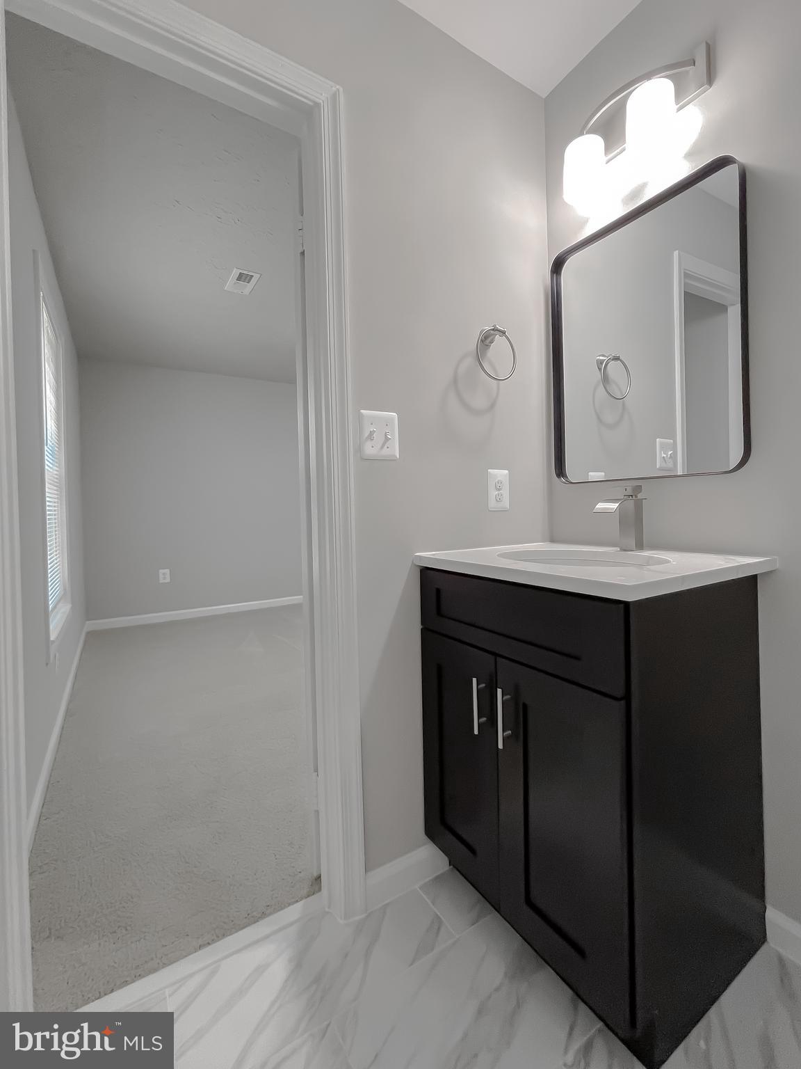 29810 Washington Road Mechanicsville, MD 20659 - Photo 43 of 44 a bathroom with a sink vanity and mirror