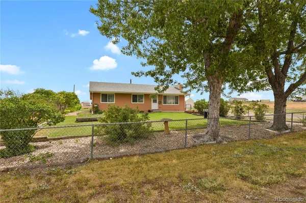 a view of a house with backyard and a tree