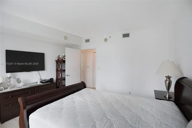 a bed sitting in a bedroom next to a window with potted plant