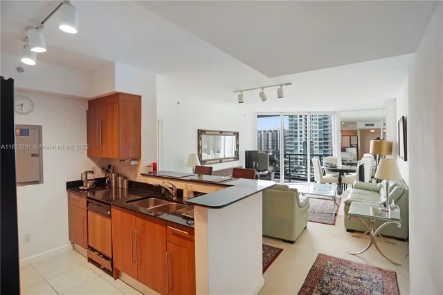 a living room with furniture a rug and kitchen view
