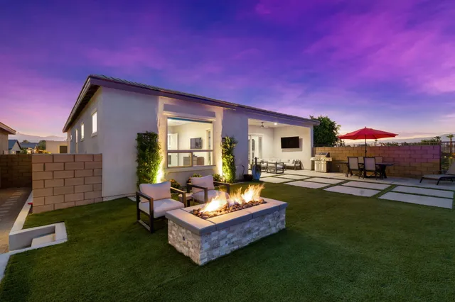 a kitchen with stainless steel appliances a stove a refrigerator a oven a sink a table and chairs