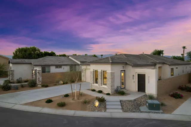 a front view of house with yard and mountain view in back