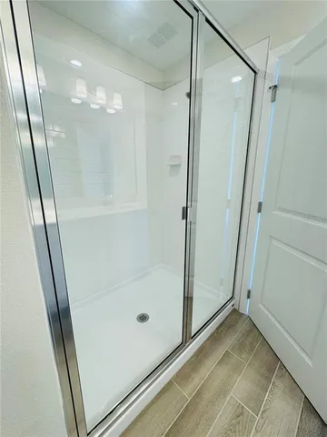 a bathroom with a glass door shower and vanity