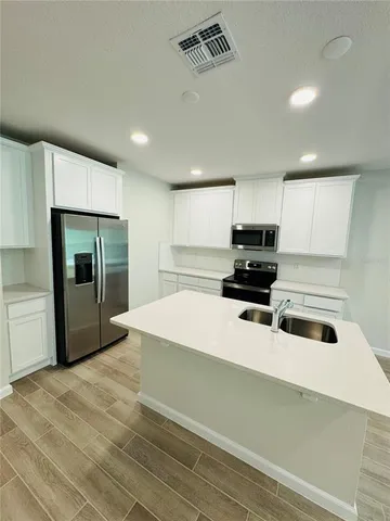 a kitchen with a refrigerator and a sink