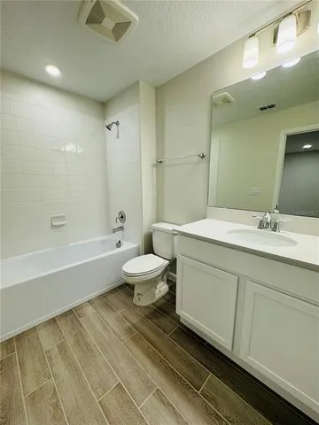 a bathroom with a double vanity sink a toilet and a bathtub